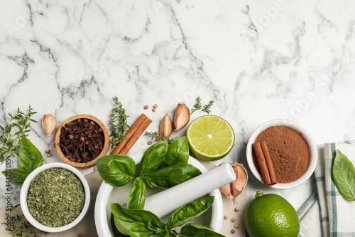 Fototapeta Naklejka Na Ścianę i Meble -  Different natural spices and herbs on white marble table, flat lay. Space for text