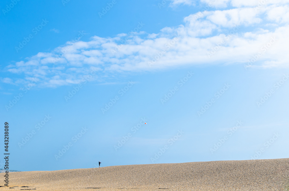 Man flying a kite at Chesil beach, Dorset