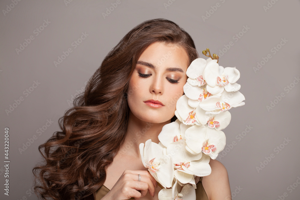 Nice brunette fashion woman with flowers. Model with nude makeup. Beauty face. Studio shot