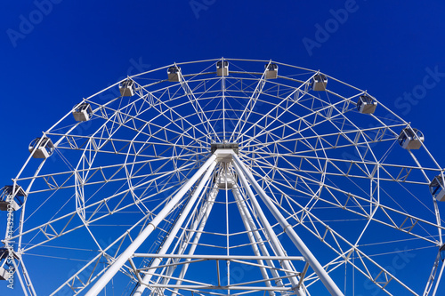 white ferris wheel against a bright blue sky