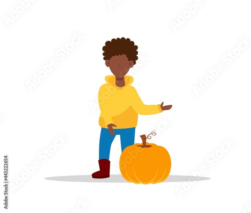 African-American boy in yellow hoodie with pumpkin. A