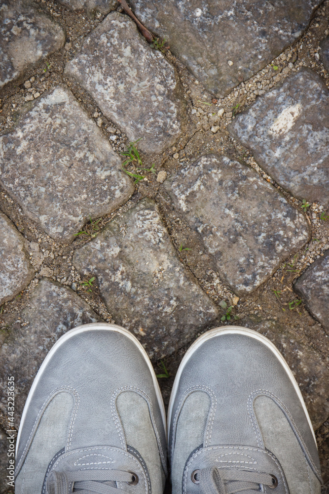 Comfortable gray leather shoes for men on road or footpath made of rocks or stones. Male footwear. Place for text Comfortable gray leather shoes for men on road or footpath made of rocks or stones. Male footwear. Place for text