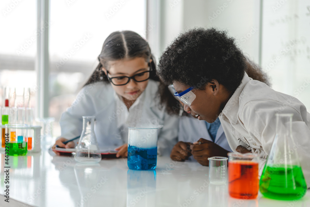 Group of teenage cute little student child learning research and doing a chemical experiment while making analyzing and mixing liquid in test tube at experiment laboratory class at school.Education Group of teenage cute little student child learning research and doing a chemical experiment while making analyzing and mixing liquid in test tube at experiment laboratory class at school.Education