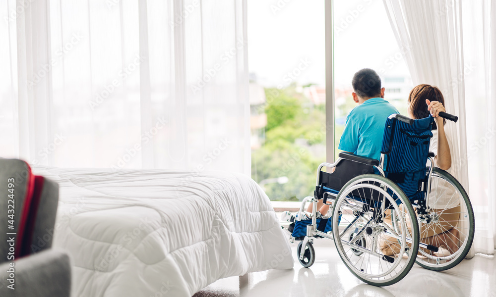 Portrait of enjoy happy love family asian mother playing and carer helping look at disabled son child sitting in wheelchair moments good time at home.disability care concept Portrait of enjoy happy love family asian mother playing and carer helping look at disabled son child sitting in wheelchair moments good time at home.disability care concept