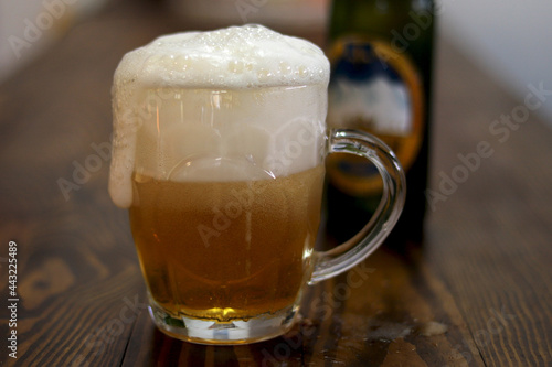 a glass of foamy fresh cold beer on the table