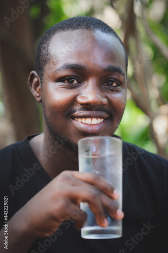 African man holding glass of water drink clean clear mineral aqua for body refreshment. Hydration concept