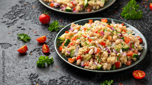 Quinoa white bean salad with cherry tomatoes, cucumber, red onion and herbs. Healthy vegan food