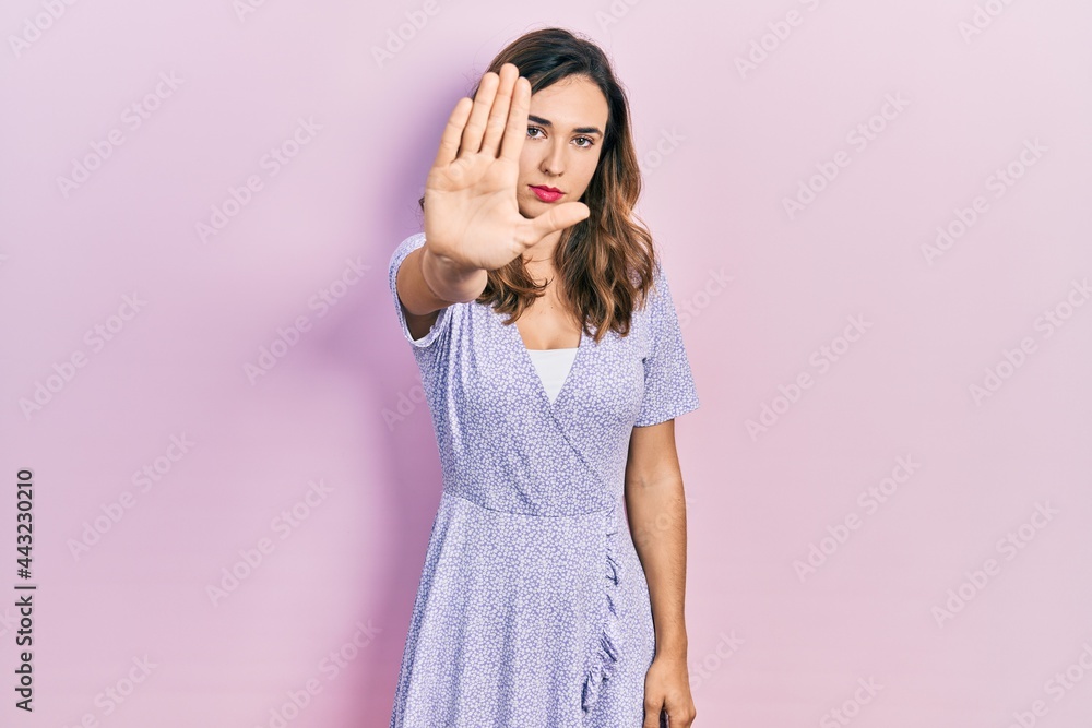 Young hispanic girl wearing casual clothes doing stop sing with palm of the hand. warning expression with negative and serious gesture on the face. Young hispanic girl wearing casual clothes doing stop sing with palm of the hand. warning expression with negative and serious gesture on the face.