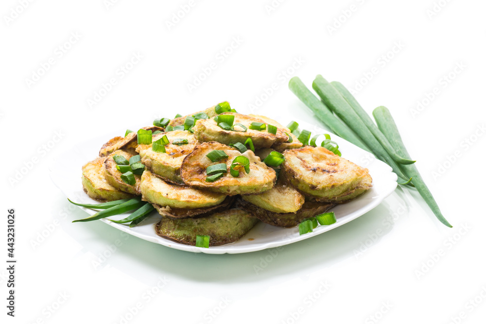 fried zucchini in circles with fresh herbs in a plate isolated on white fried zucchini in circles with fresh herbs in a plate isolated on white