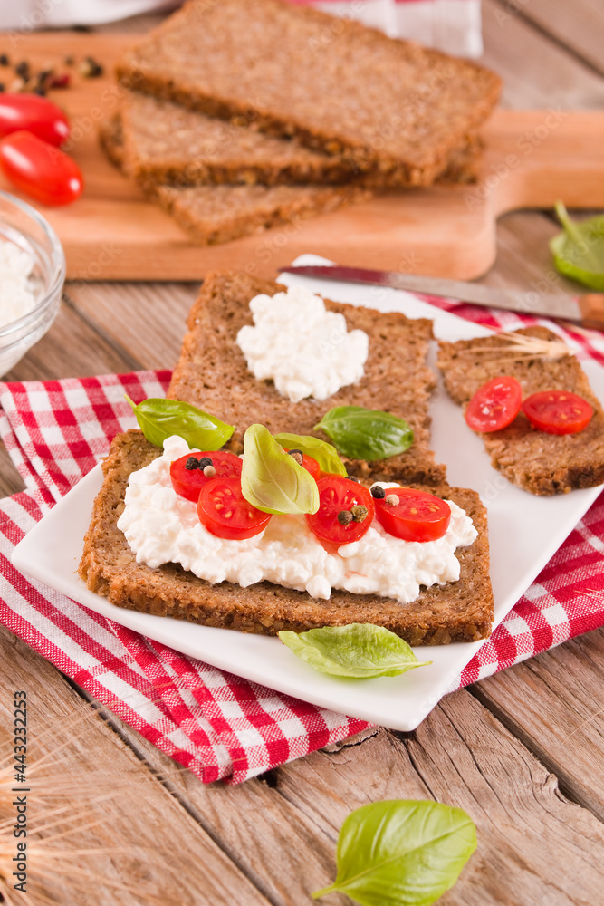 Rye bread with cottage cheese, basil and tomato.