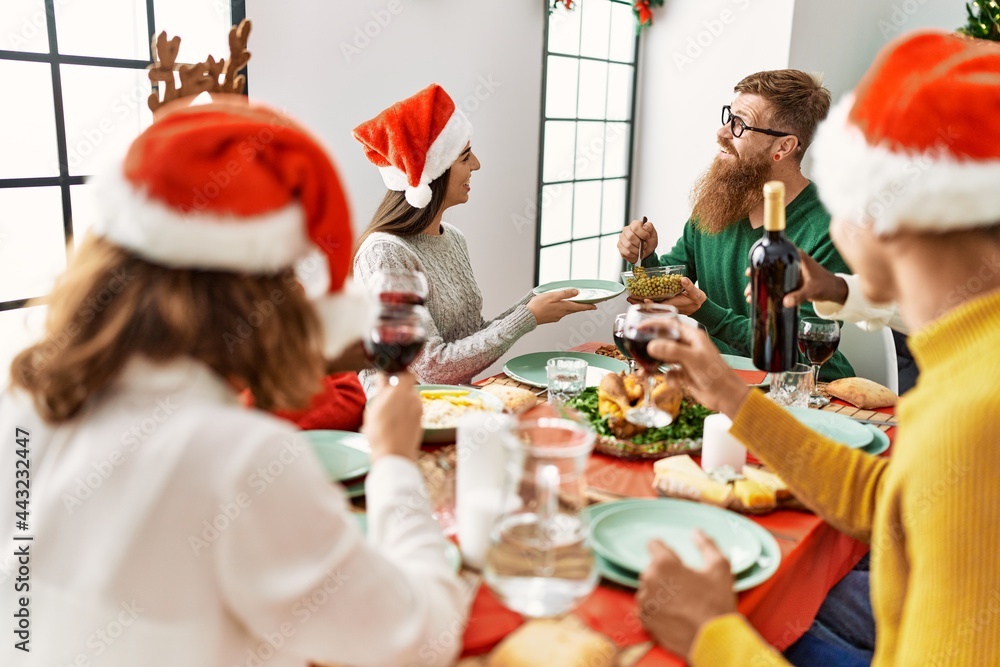 Fototapeta premium Group of young people smiling happy having christmas dinner at home.