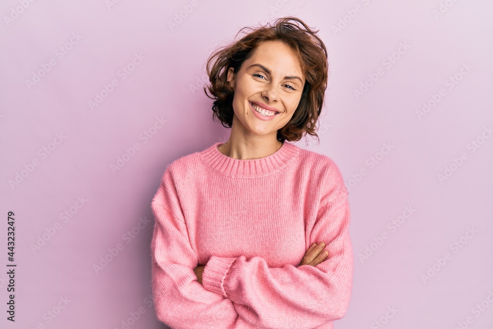 Fototapeta premium Young brunette woman wearing casual winter sweater happy face smiling with crossed arms looking at the camera. positive person.