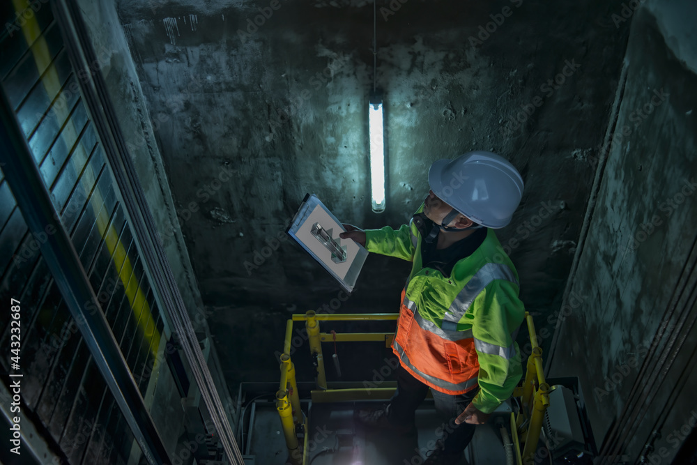 worker service check  elevator. service  engineer work in elevator shaft.