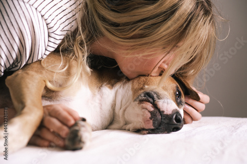 Принти на полотні Young woman lies close to her dog und kisses her