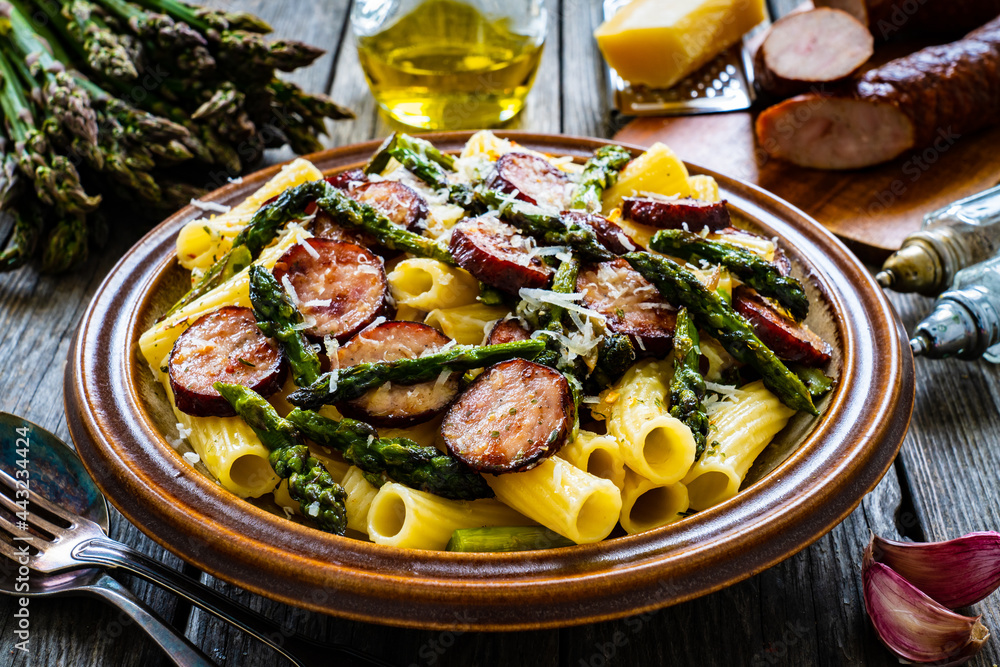 Tortiglioni with sausages, parmesan and asparagus on wooden table
Tortiglioni with sausages, parmesan and asparagus on wooden table