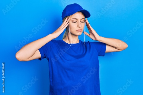 Young caucasian woman wearing courier uniform wearing cap suffering from headache desperate and stressed because pain and migraine. hands on head.