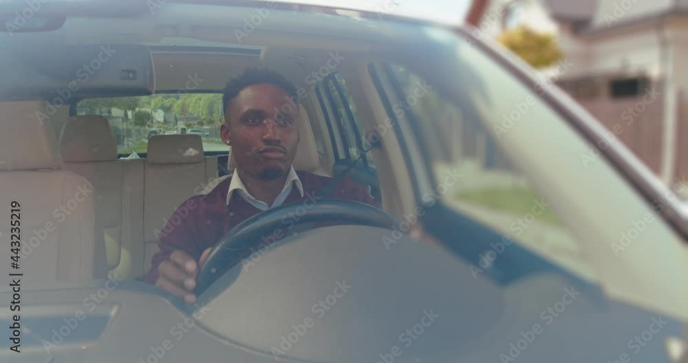 Happy young african american man is driving a car on a road looking ...