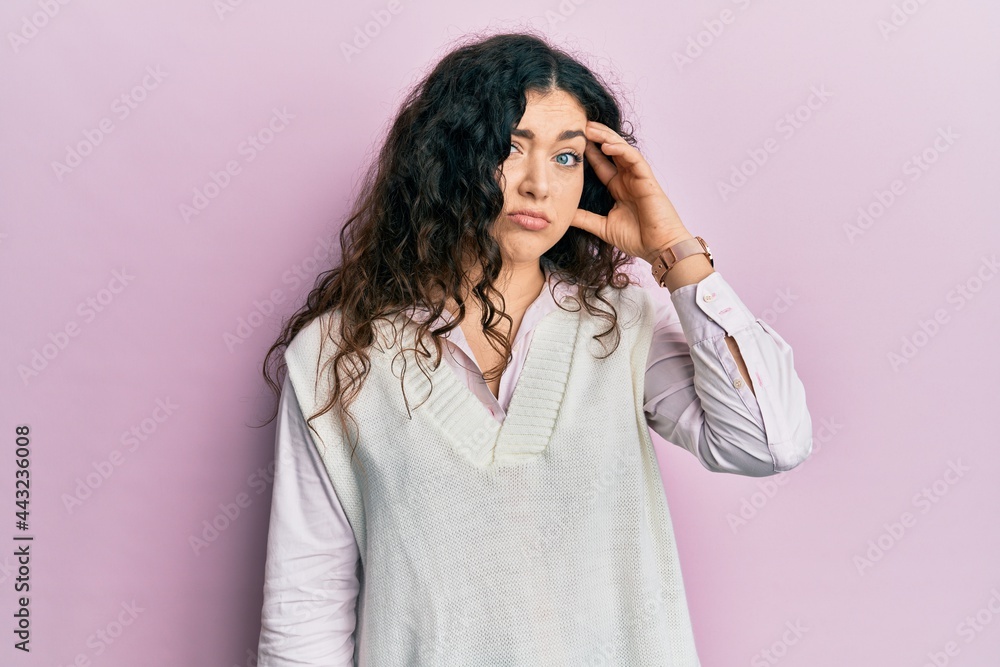 Young brunette woman with curly hair wearing casual clothes worried and stressed about a problem with hand on forehead, nervous and anxious for crisis Young brunette woman with curly hair wearing casual clothes worried and stressed about a problem with hand on forehead, nervous and anxious for crisis