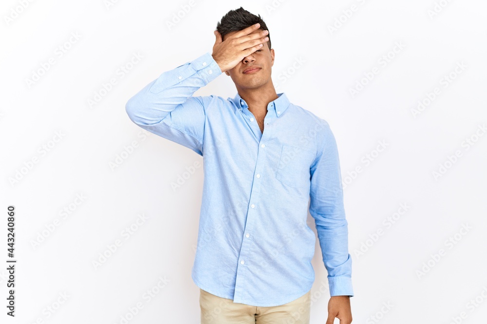 Young hispanic man wearing business shirt standing over isolated background covering eyes with hand, looking serious and sad. sightless, hiding and rejection concept Young hispanic man wearing business shirt standing over isolated background covering eyes with hand, looking serious and sad. sightless, hiding and rejection concept
