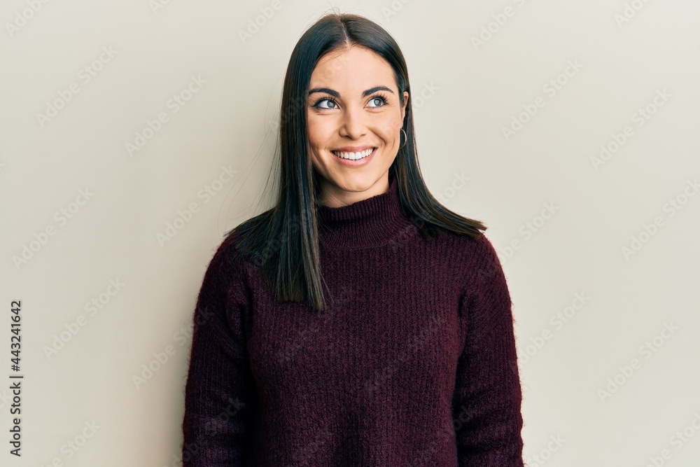Young brunette woman wearing casual winter sweater looking to side, relax profile pose with natural face and confident smile. Young brunette woman wearing casual winter sweater looking to side, relax profile pose with natural face and confident smile.