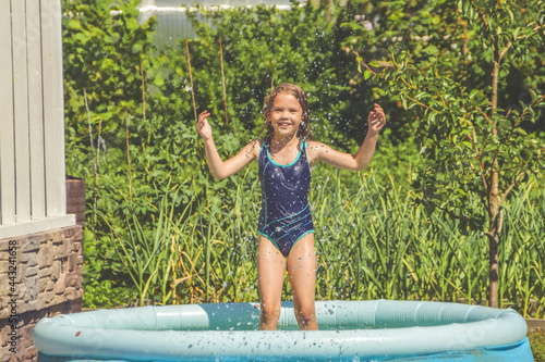 the girl child is splashing in the pool on the street