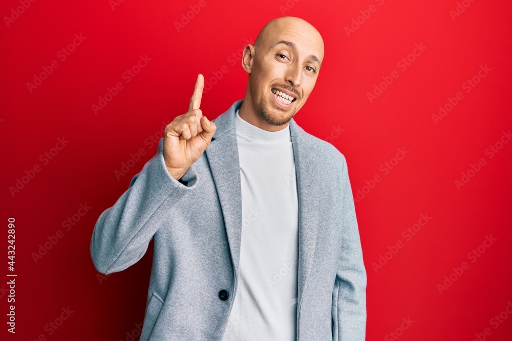 Bald man with beard wearing business jacket smiling with an idea or question pointing finger up with happy face, number one Bald man with beard wearing business jacket smiling with an idea or question pointing finger up with happy face, number one