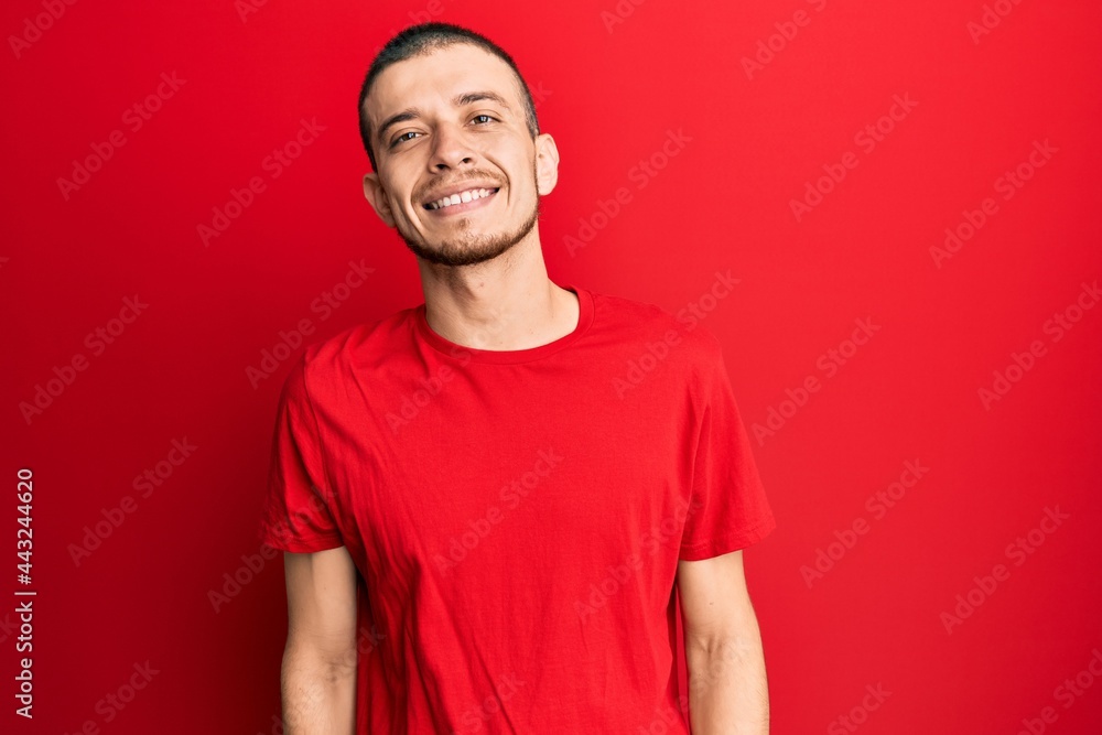 Obraz premium Hispanic young man wearing casual red t shirt with a happy and cool smile on face. lucky person.