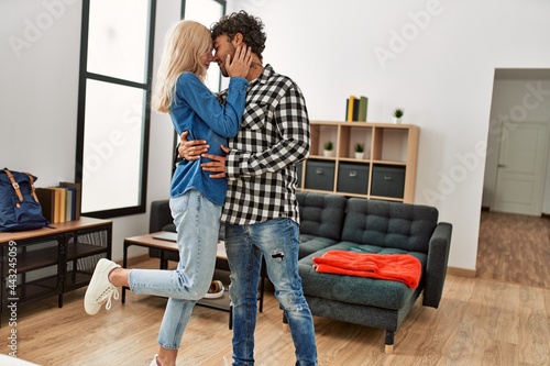 Young couple smiling happy dancing at home.