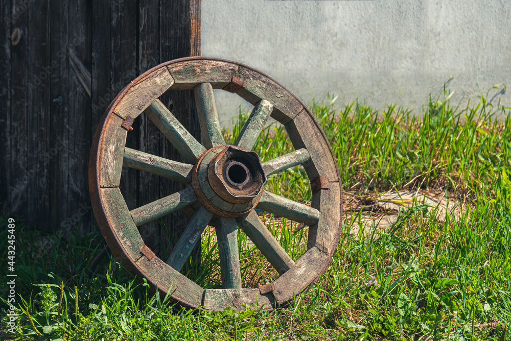 An ancient wooden cartwheel near the porch door. An ancient wooden cartwheel near the porch door.