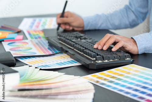 creative graphic designer choosing color scale for editing artwork while working in office.