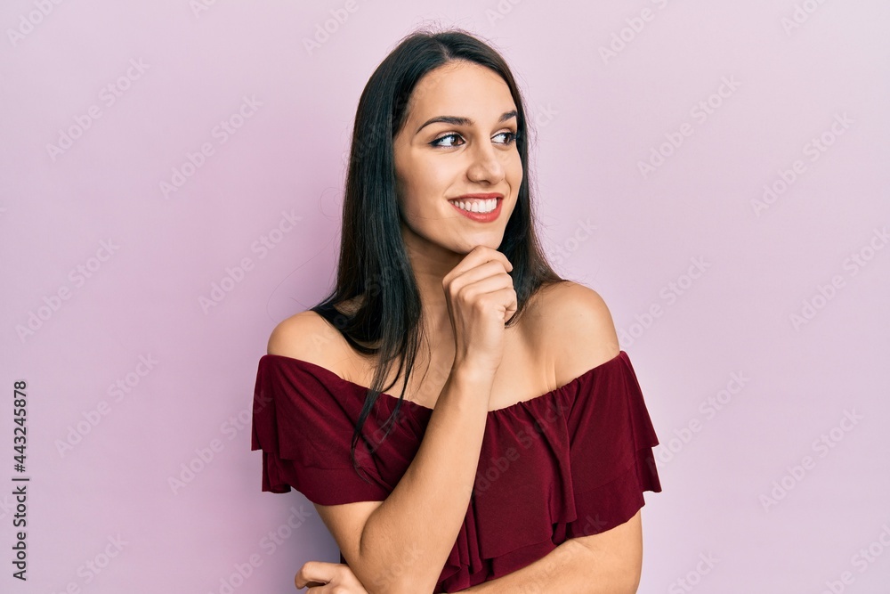 Young hispanic woman wearing casual clothes with hand on chin thinking about question, pensive expression. smiling with thoughtful face. doubt concept. Young hispanic woman wearing casual clothes with hand on chin thinking about question, pensive expression. smiling with thoughtful face. doubt concept.