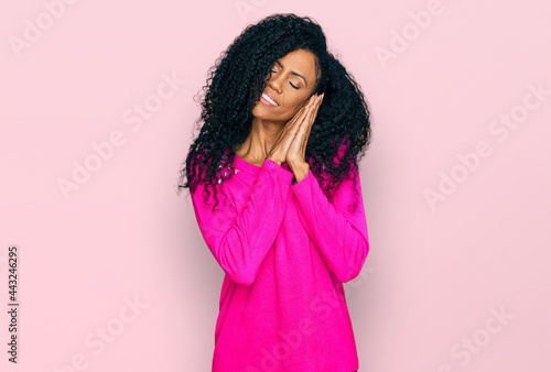 Middle age african american woman wearing casual clothes sleeping tired dreaming and posing with hands together while smiling with closed eyes.