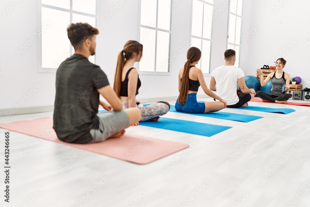 Group of young people having yoga class with personal trainer at sport center. Group of young people having yoga class with personal trainer at sport center.