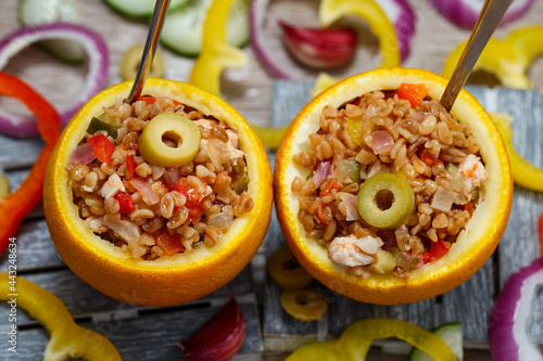 Foto An exotically decorated dish of bulgur, poultry and vegetables with oranges