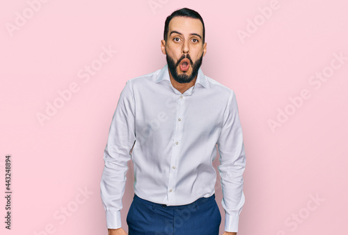 Young man with beard wearing business shirt afraid and shocked with surprise expression, fear and excited face.