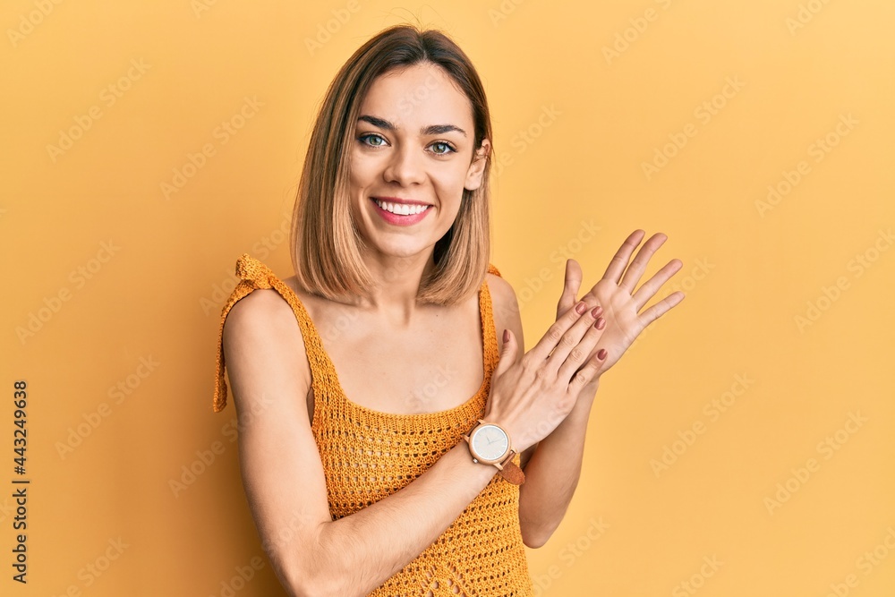 Young caucasian blonde woman wearing casual yellow t shirt clapping and applauding happy and joyful, smiling proud hands together Young caucasian blonde woman wearing casual yellow t shirt clapping and applauding happy and joyful, smiling proud hands together