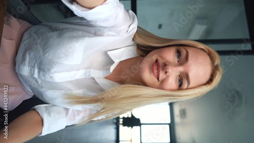Close-up face of attractive blonde female office worker listening to interlocutor during talking over video chat conference call recording vlog. Portrait of prett young woman listens to customer. photo