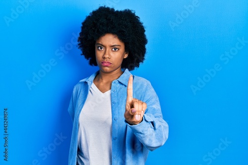 Young african american woman wearing casual clothes pointing with finger up and angry expression, showing no gesture