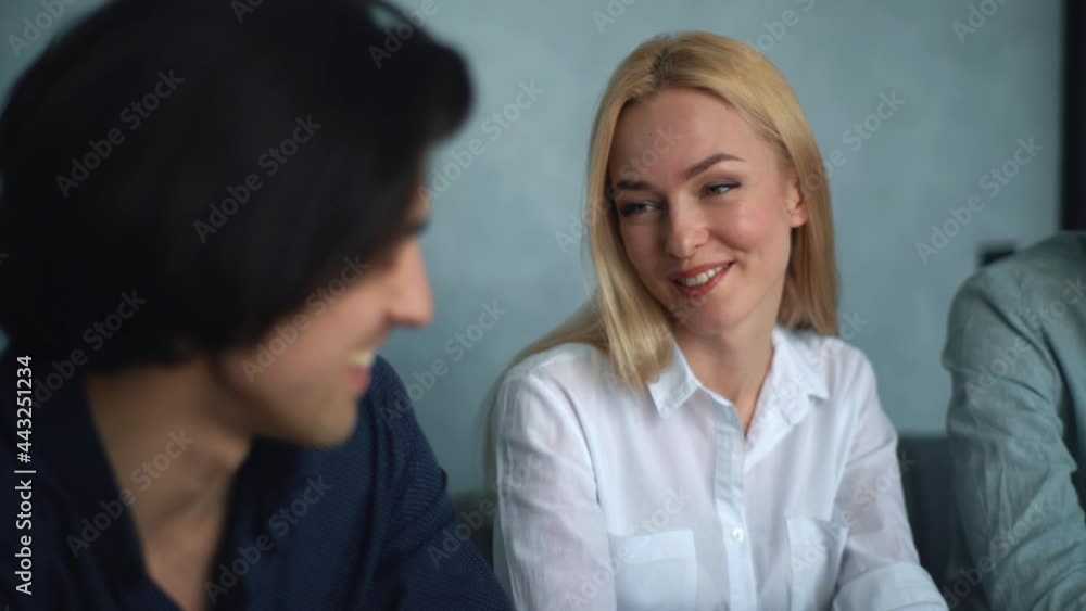 Close-up of young business people startup team coworkers laughing at workplace during informal discussion in loft office. Caucasian group of young people discussing start-up ideas, cheerful mood. Close-up of young business people startup team coworkers laughing at workplace during informal discussion in loft office. Caucasian group of young people discussing start-up ideas, cheerful mood.