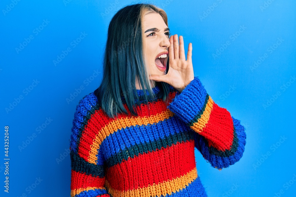 Young modern girl wearing casual white t shirt shouting and screaming loud to side with hand on mouth. communication concept. Young modern girl wearing casual white t shirt shouting and screaming loud to side with hand on mouth. communication concept.
