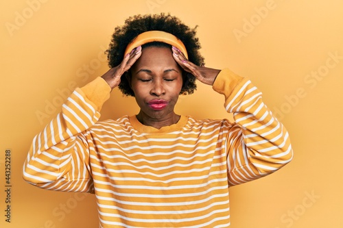 Young african american woman wearing casual sweatshirt with hand on head, headache because stress. suffering migraine. © Krakenimages.com