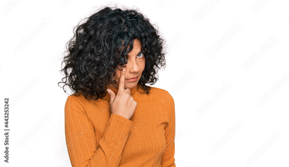 Young hispanic woman wearing casual clothes pointing to the eye watching you gesture, suspicious expression Young hispanic woman wearing casual clothes pointing to the eye watching you gesture, suspicious expression