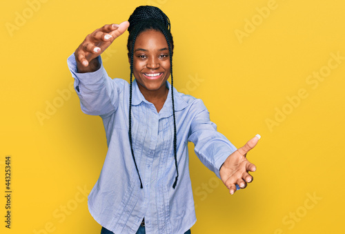 Young african american woman wearing casual clothes looking at the camera smiling with open arms for hug. cheerful expression embracing happiness.