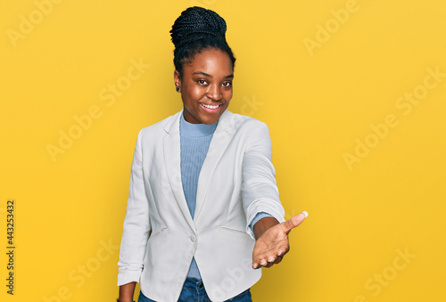 Quadro su tela Young african american woman wearing business clothes smiling cheerful offering palm hand giving assistance and acceptance