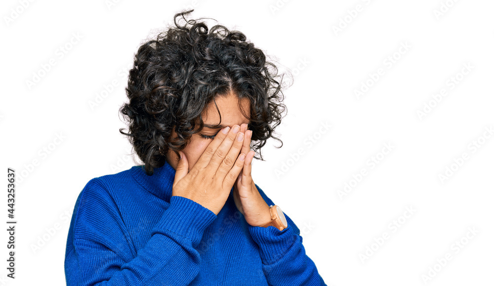 Young hispanic woman with curly hair wearing turtleneck sweater with sad expression covering face with hands while crying. depression concept. Young hispanic woman with curly hair wearing turtleneck sweater with sad expression covering face with hands while crying. depression concept.