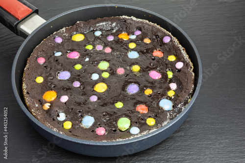 chocolate cookie with colorful chocolate drops baked in a skillet