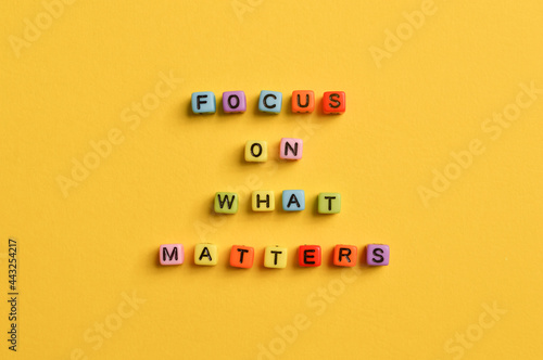 Alphabet letters with text FOCUS ON WHAT MATTERS isolated on yellow background