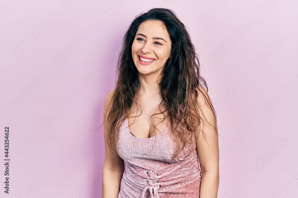 Young hispanic woman wearing casual clothes looking away to side with smile on face, natural expression. laughing confident. Young hispanic woman wearing casual clothes looking away to side with smile on face, natural expression. laughing confident.