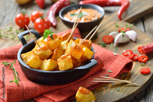 Patatas Bravas mit scharfer Chili-Sauce, ein Klassiker unter den spanischen Tapas-Gerichten – Spanish fried potato cubes with spicy chili sauce, traditional appetizers photo