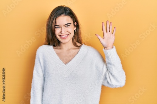 Wallpaper Mural Young caucasian girl wearing casual clothes showing and pointing up with fingers number five while smiling confident and happy. Torontodigital.ca
